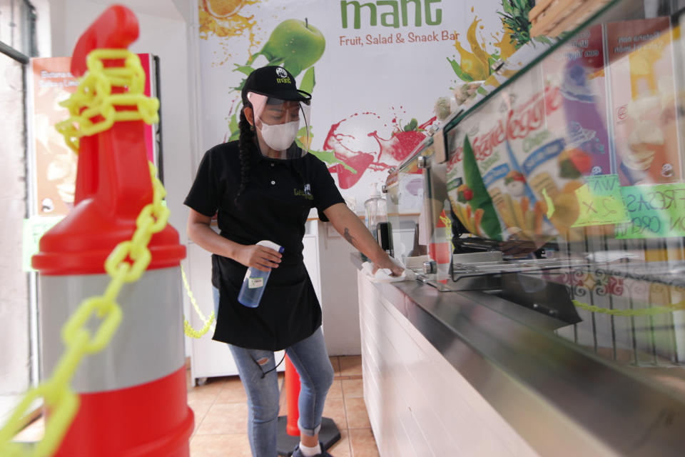 QUERETARO, MEXICO - JUNE 25: A worker cleans a fridge in a ice-cream parlour as Businesses reopen their doors to customers on June 25, 2020 in Queretaro, Mexico. Lockdown restrictions ease as half of the states switch to orange level of alert and the capital amongst other states remain in red alert.  (Photo by Cesar Gomez/Jam Media/Getty Images)