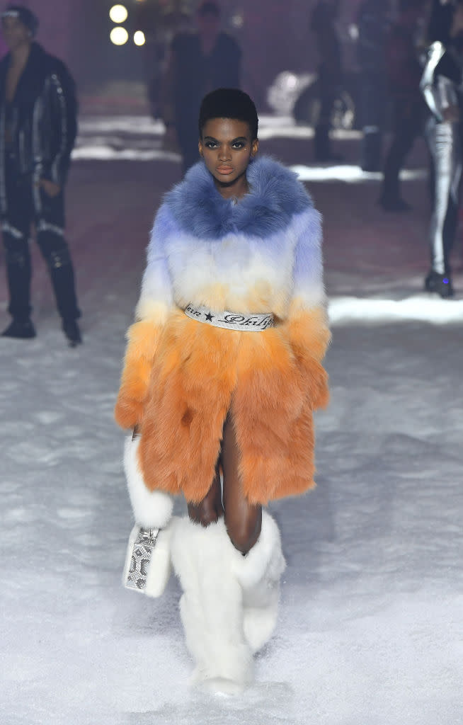 <p>Model wears a blue, orange, and white fur coat and white fur boots at the Philipp Plein FW18 show. (Photo: Getty) </p>