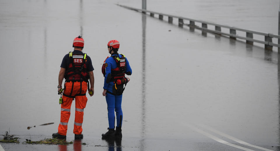 SES flood rescue team members inspect floodwaters flowing over the New Windsor Bridge at Windsor in north western Sydney, Tuesday, March 23, 2021. Source: AAP