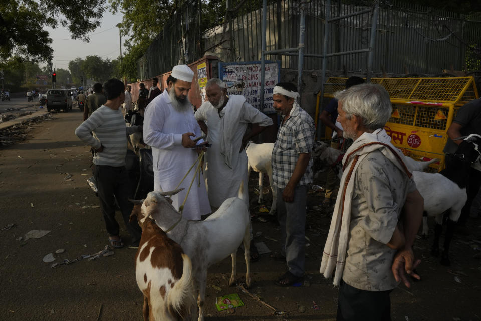 A Muslim makes online transfer of money through his mobile phone after buying goats for Eid al Ada, near the Jama Masjid, in New Delhi, India, Monday, June 17, 2024. Muslims around the world celebrate Eid al-Adha by sacrificing animals to commemorate the prophet Ibrahim's faith in being willing to sacrifice his son. (AP Photo/Manish Swarup)