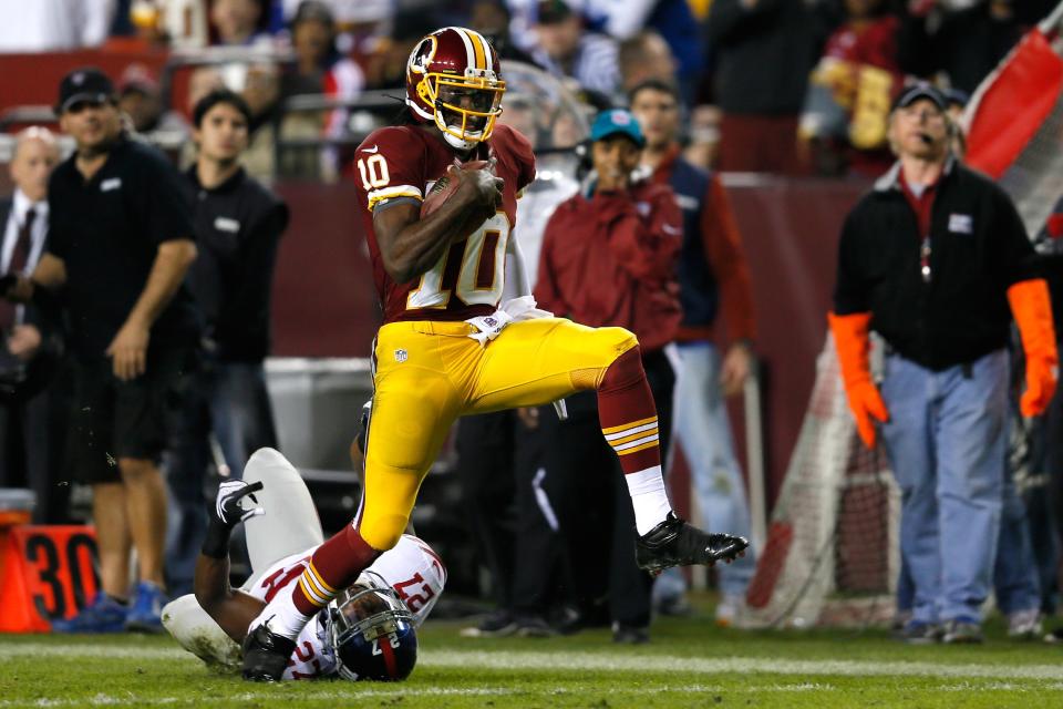 Quarterback Robert Griffin III #10 of the Washington Redskins runs for a 46-yard gain as he is taken down by Stevie Brown #27 of the New York Giants in the second half at FedExField on December 3, 2012 in Landover, Maryland. (Photo by Rob Carr/Getty Images)