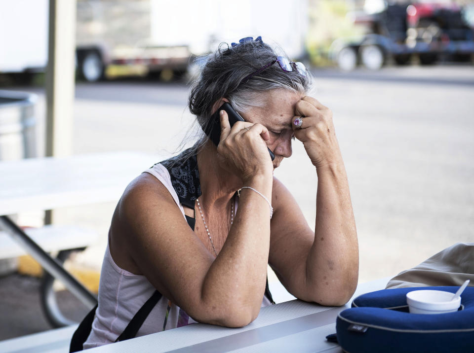 In this Thursday, Aug. 30, 2018 photo, Diane Jones, a passenger on the Greyhound bus that was involved in a deadly collision with a semi-truck on I-40 near Thoreau, talks on the phone at a hospital in Gallup. N.M., where she was treated. The Greyhound bus carrying nearly 50 people was headed west along Interstate 40 on Thursday when a semitrailer going in the opposite direction lost the tread on its left front tire and veered across a median and smashed into the bus, police said. (Alma E. Hernandez/Gallup Independent via AP)