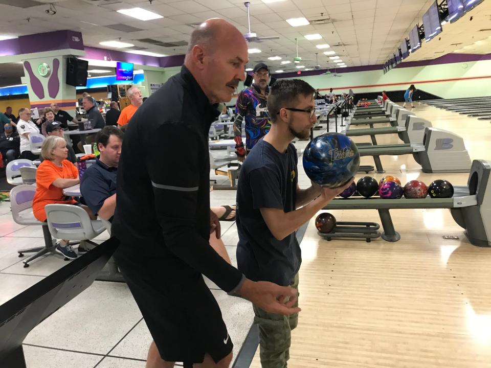 Former Detroit Tigers outfielder Kirk Gibson helps a young man at Willie Horton's charity bowling tournament at Orange Bowl in Lakeland, Fla., on  March 9, 2023.