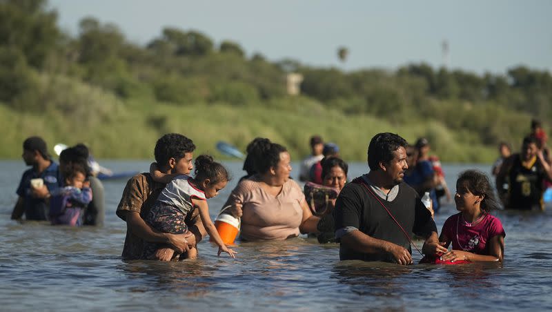 Migrants navigate around concertina wire along the banks of the Rio Grande after crossing from Mexico into the U.S., Tuesday, Aug. 1, 2023, in Eagle Pass, Texas. The number of illegal crossings at the U.S.-Mexico border are up from last month.