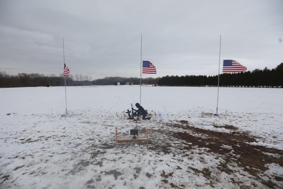 Several people, including Charles Nadeau of Avon, stopped at the memorial erected along W. Bloomfield Road in Mendon, January 26, 2021.  Three soldiers were killed when their helicopter crashed during a National Guard training exercise last week.