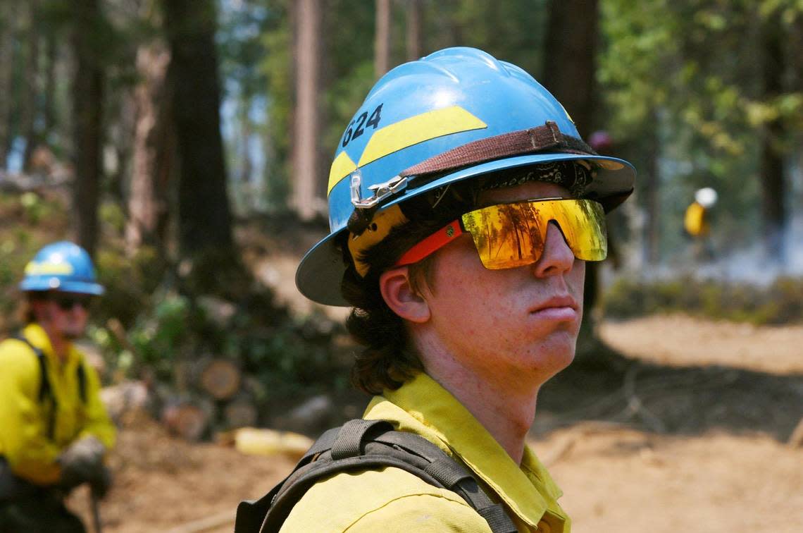 Firefighter Bryce McGeehee, center, from Mt. Adams Wildfire keeps an eye out for any flareups in the forest along Wawona Road between Wawona and the south entrance as the Washburn Fire continues to burn in Yosemite National Park Monday, July 11, 2022.