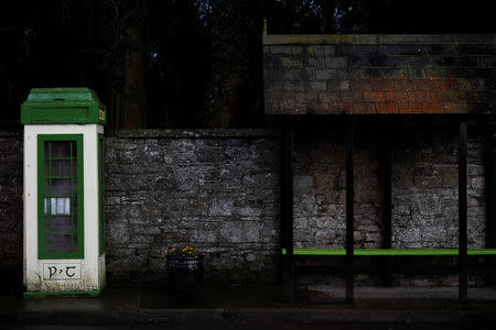 A old Irish phone box stands alongside a bus stop in the border town of Glaslough, Ireland, March 16, 2018. REUTERS/Clodagh Kilcoyne
