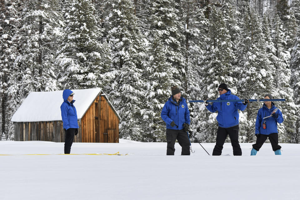 In this photo provided by the California Department of Water Resources, forecasting chief Sean de Guzman, second from right, and engineers work the measurement phase of the first media snow survey of the season at Phillips Station in the Sierra Nevada Mountains, Calif., Tuesday, Jan. 3, 2023. The snowpack in California's mountains is off to one of its best starts in 40 years, officials announced Tuesday, offering hope that the drought-stricken state could soon see relief in the spring when the snow melts and flows into reservoirs that provide water for drinking and farming. (Kenneth James/California Department of Water Resources via AP)