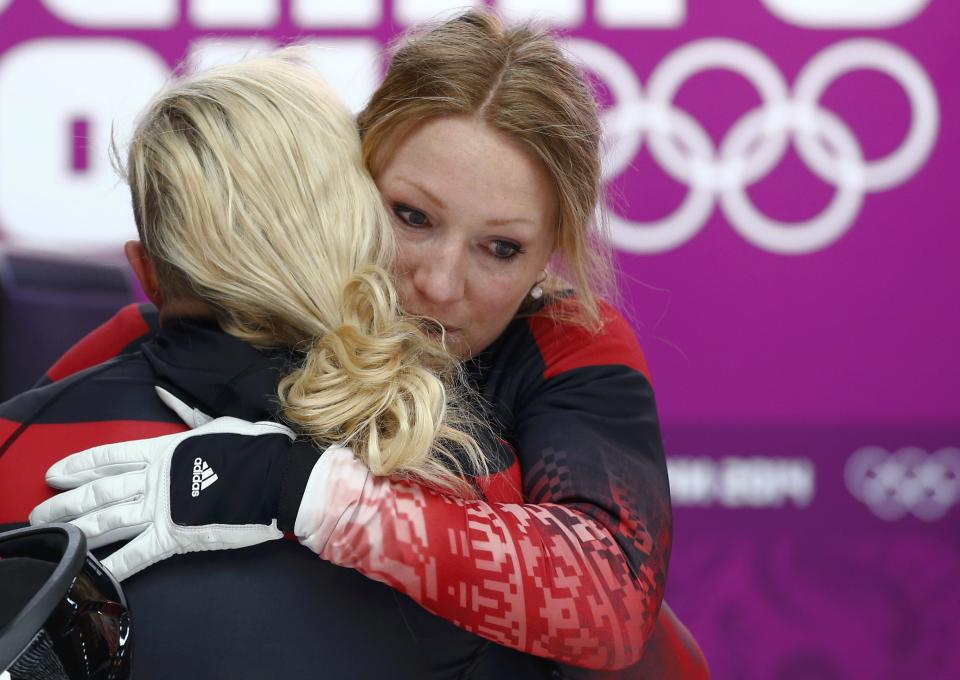 Canada's pilot Kaillie Humphries (L) hugs teammate Heather Moyse after completing a run in the women's bobsleigh event at the 2014 Sochi Winter Olympics, at the Sanki Sliding Center in Rosa Khutor February 19, 2014. REUTERS/Arnd Wiegmann (RUSSIA - Tags: SPORT BOBSLEIGH OLYMPICS)