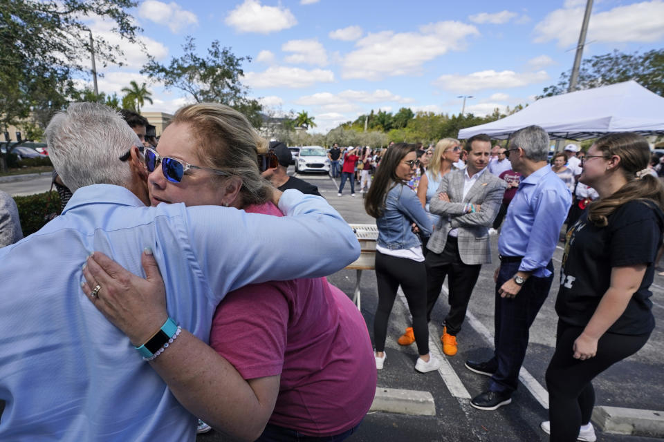 Jennifer Montalto, second from left, mother of shooting victim Gina Montalto, gets a hug, Tuesday, Feb. 14, 2023, at a ceremony in Coral Springs, Fla., honoring the lives of the 17 students and staff of Marjory Stoneman Douglas High School that were killed on Valentine's Day in 2018. (AP Photo/Wilfredo Lee)