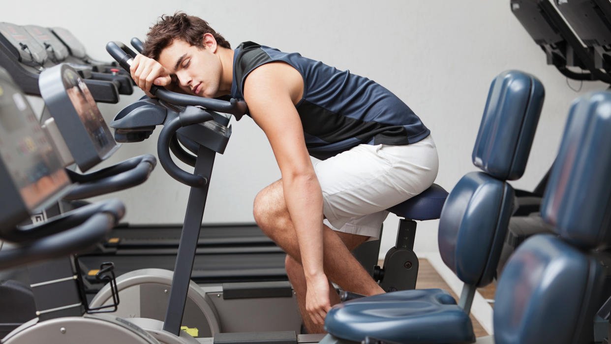  Man asleep on exercise bike. 