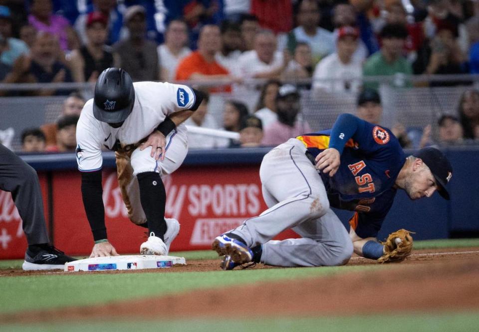 Miami Marlins shortstop Jon Berti (5) steals third base and is safe from Houston Astros third baseman Alex Bregman (2) during a baseball game on Monday, Aug. 14, 2023, at loanDepot Park in Miami.