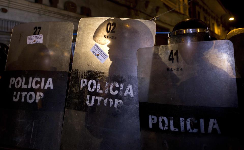 <p>Die Polizei im bolivianischen La Paz versucht, Demonstranten davon abzuhalten, in den Nationalpalast vorzudringen, wo sich die Büroräume von Präsident Evo Morales befinden. Auf den Schildern der Polizei sind von den Demonstranten aufgeklebte Anti-Morales-Aufkleber zu sehen, auf denen „Wählt am 3. Dezember ungültig. Gegen Korruption. Gegen Wiederwahl“, zu lesen ist. Boliviens Oberster Gerichtshof entschied, dass Morales sich ein viertes Mal zur Wahl stellen darf. (Bild: AP Photo/Juan Karita) </p>