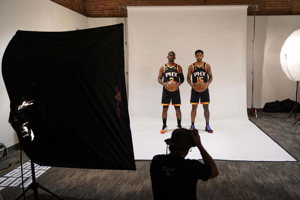 Phoenix Suns' Chris Paul, left, and Cameron Payne pose for a photo with team photographer Barry Gossage during an NBA basketball media day, Monday, Sept. 26, 2022, in Phoenix. (AP Photo/Matt York)