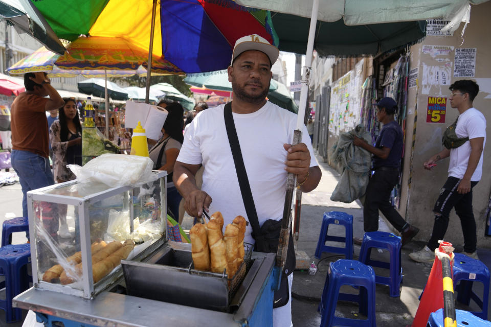 Venezuelan Giovanny Tovar waits for customers at his tequeños or fried breaded cheese sticks' street cart, in Lima, Peru, Saturday, April 13, 2024. Tovar is one of millions of Venezuelans living abroad who will not be able to cast his vote in the July 28th presidential election. (AP Photo/Martin Mejia)