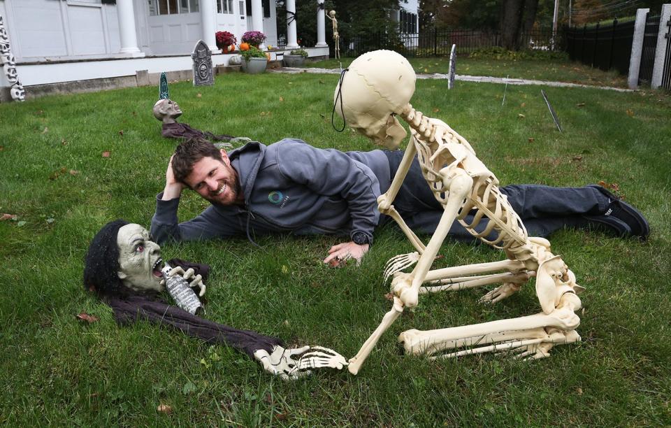 Aaron Berlin lies in a fake graveyard he and his family created on Summer Street in Kennebunk for Halloween.