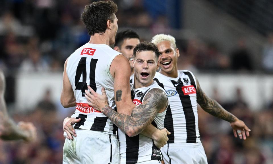 <span>Collingwood’s Jamie Elliott (centre) celebrates kicking a goal during the AFL grand final rematch against Brisbane at the Gabba.</span><span>Photograph: Darren England/AAP</span>