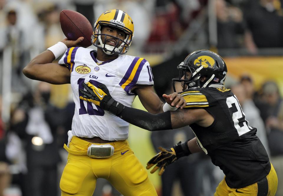 LSU quarterback Anthony Jennings (10) throws a pass as he gets hit by Iowa linebacker Christian Kirksey (20) during the first quarter of the Outback Bowl NCAA college football game Wednesday, Jan. 1, 2014, in Tampa, Fla. (AP Photo/Chris O'Meara)