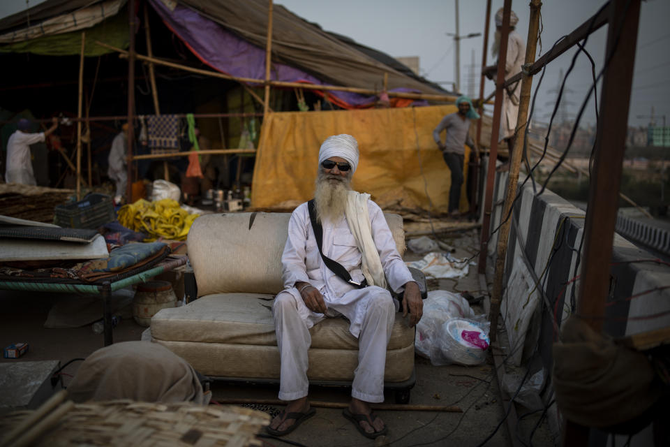 An elderly Sikh farmer sits on a sofa as he takes a break while dismantling temporary structures used during protests in Ghazipur, outskirts of New Delhi, India, Friday, Dec. 10, 2021. Thousands of Indian farmers suspended their year-long protest on Thursday after the government withdrew contentious farm laws and set up a committee to consider their other demands, including guaranteed prices for key crops and the withdrawal of criminal cases against the protesters. (AP Photo/Altaf Qadri)
