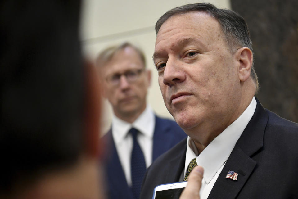 U.S. Secretary of State Mike Pompeo speaks to the media before departing from al-Bateen Air Base in Abu Dhabi, United Arab Emirates, Thursday, Sept. 19, 2019, as U.S. special representative on Iran Brian Hook, left, listens. (Mandel Ngan/Pool via AP)