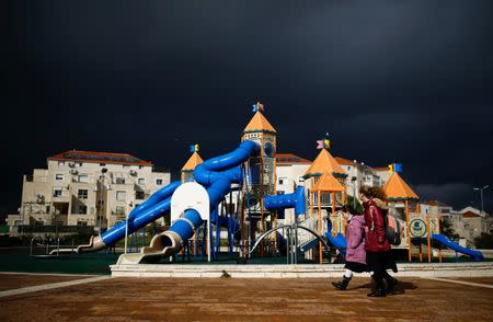 Girls walk in a playground on a stormy day in the Israeli settlement of Beitar Illit in the occupied West Bank. REUTERS/Amir Cohen