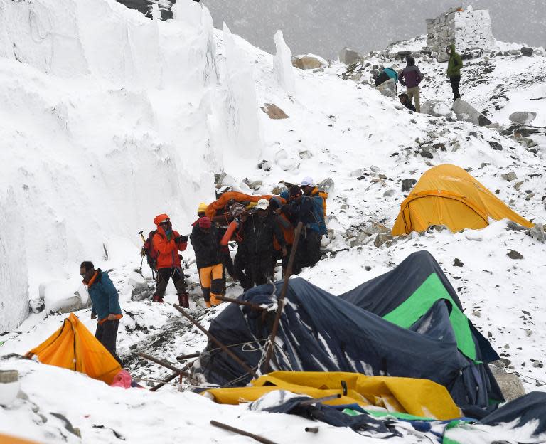 Rescuers carry a sherpa injured by an avalanche that flattened parts of Everest Base Camp, on April 25, 2015