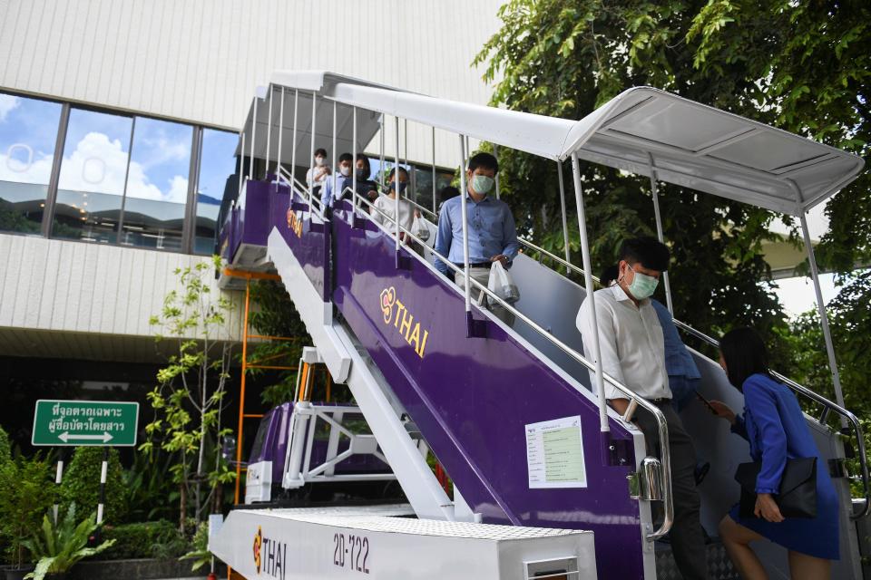 Customers walk out of the Thai Airways pop-up airplane-themed restaurant at the airlines headquarters with onboard meals prepared by their chefs, while their fleet is still grounded at the airport and the company awaits a bankruptcy court decision, in Bangkok, Thailand September 3, 2020. REUTERS/Chalinee Thirasupa