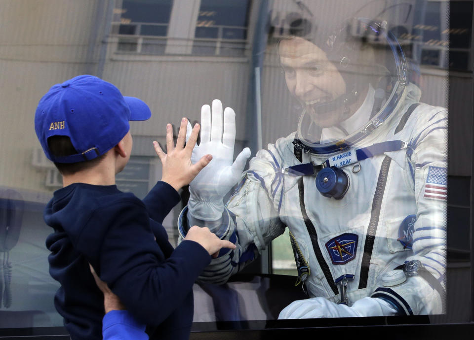 U.S. astronaut Nick Hague, member of the main crew to the International Space Station (ISS), waves to his son from a bus prior to the launch of Soyuz-FG rocket at the Russian leased Baikonur cosmodrome, Kazakhstan, Thursday, Oct. 11, 2018. (AP Photo/Dmitri Lovetsky, Pool)