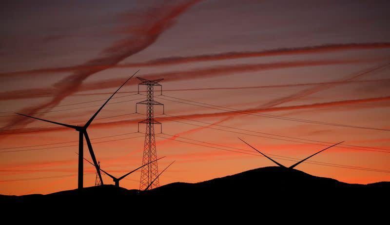 High-voltage power lines, electricity pylon and wind turbines are seen near Pedrola