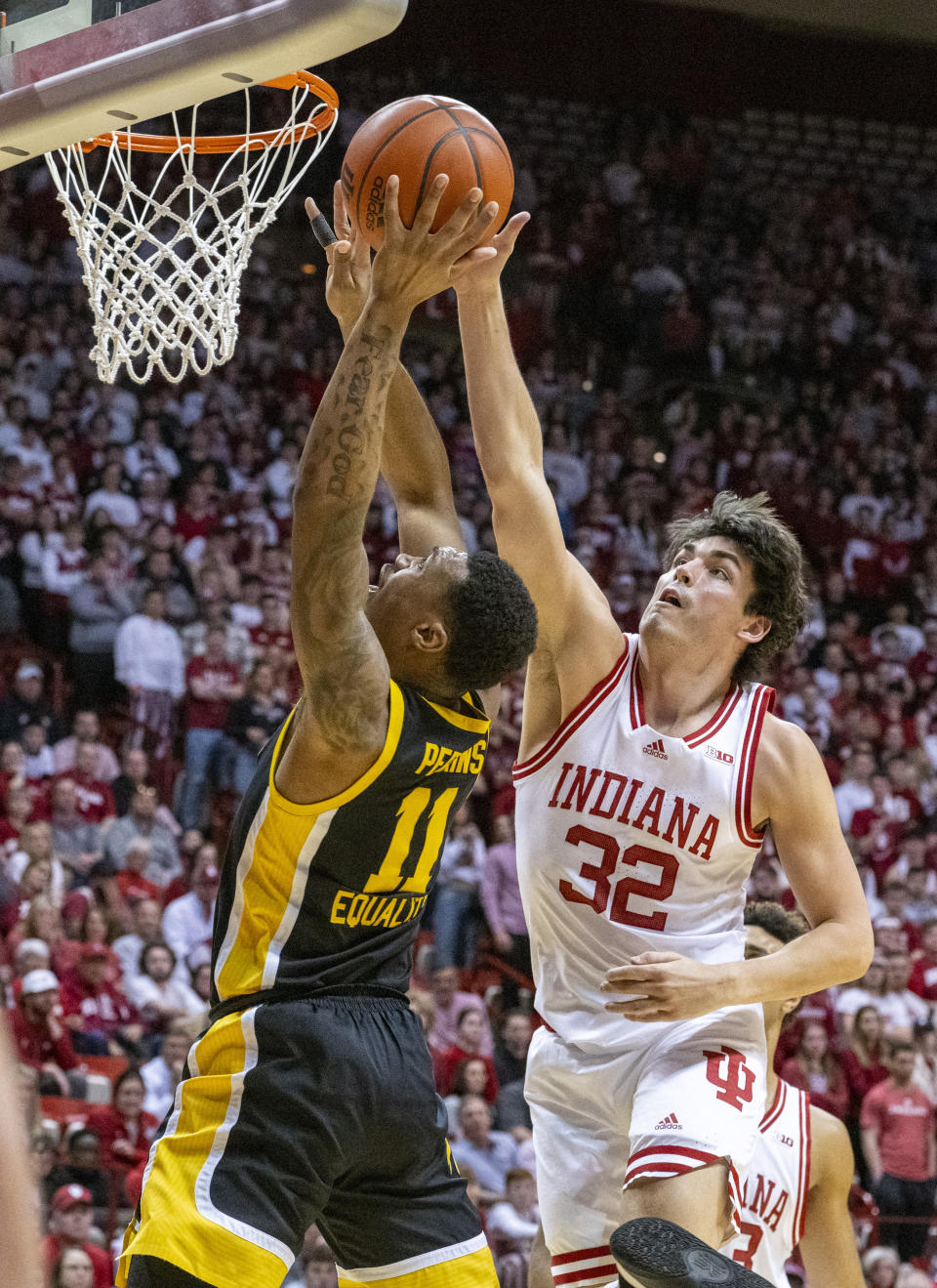 Iowa guard Tony Perkins (11) shoots against Indiana guard Trey Galloway (32) during the first half of an NCAA college basketball game Tuesday, Feb. 28, 2023, in Bloomington, Ind. (AP Photo/Doug McSchooler)