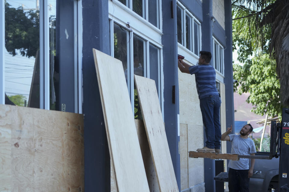 Furniture store employees board up windows for protection ahead of Hurricane Beryl's expected arrival, in Playa del Carmen, Mexico, Wednesday, July 3, 2024. (AP Photo/Fernando Llano)