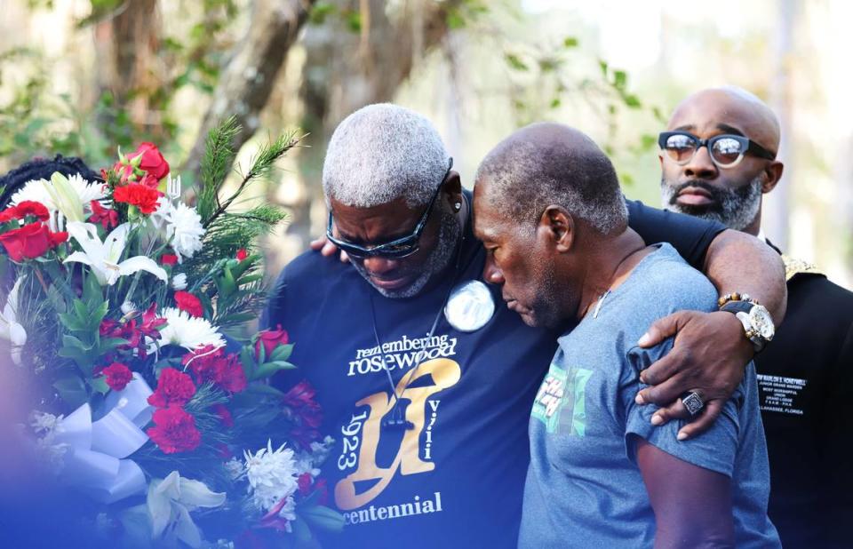 Dr. Kenneth Nunn, left, and Benjamin L. Crump, right, mourn for the victims of the Rosewood massacre that occurred a hundred years ago during a wreath-laying ceremony, at Rosewood, Fla., Sunday, Jan. 8, 2023.