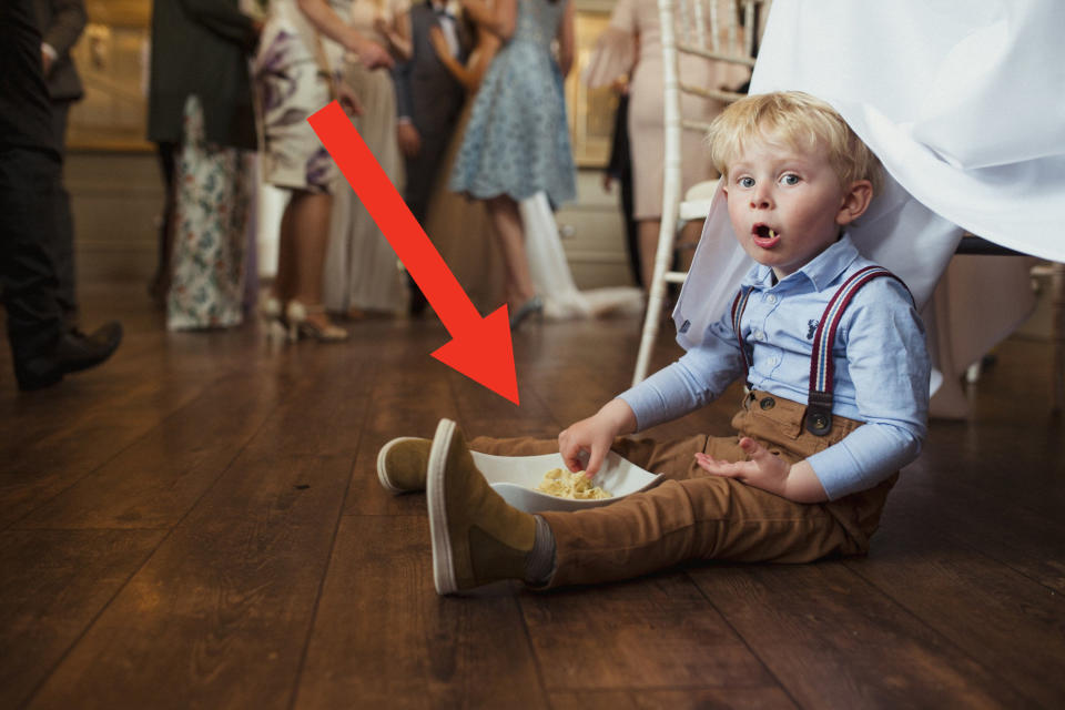 A little boy eating food on the floor