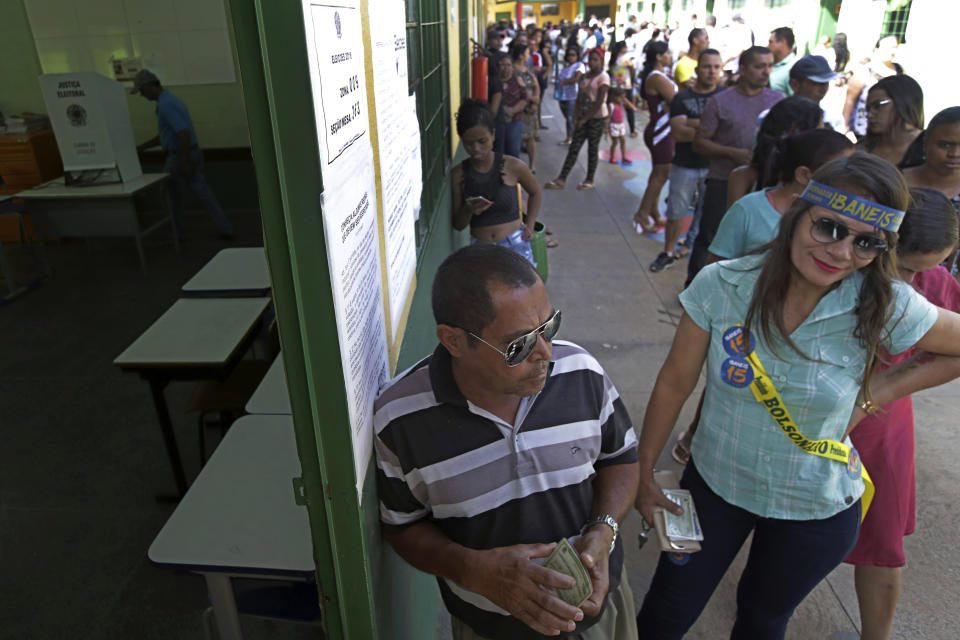 Voters wait in line at a polling station in Brasilia, Brazil, Sunday, Oct. 28, 2018. Jair Bolsonaro, presidential candidate with the Social Liberal Party is running against leftist candidate Fernando Haddad of the Workers’ Party. (AP Photo/Eraldo Peres)