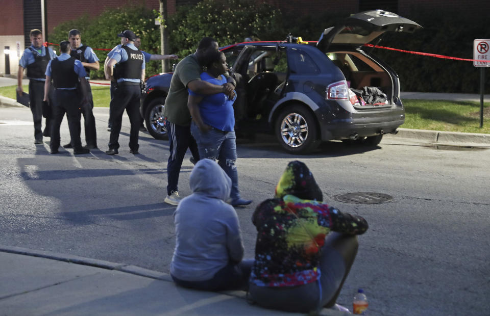 Two people walk past as police guard an SUV wherein a 3-year-old boy was fatally shot while riding in the vehicle with his father, outside West Suburban Medical Center Saturday, June 20, 2020, in Oak Park. The boy was struck in the 5600 block of West Huron Street in the Austin neighborhood, and his father drove to the hospital, where he was pronounced dead. Multiple people, including several children, were killed as more than 100 people were shot in a wave of gunfire in Chicago over the Father’s Day weekend that produced the city’s highest number of shooting victims in a single weekend this year. (John J. Kim/Chicago Tribune via AP)