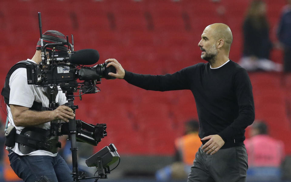 Manchester City coach Pep Guardiola covers a video camera with his hand as he leaves the field at the end of the English Premier League soccer match between Tottenham Hotspur and Manchester City at Wembley stadium in London, England, Saturday, April 14, 2018. Manchester City won 3-1. (AP Photo/Tim Ireland)