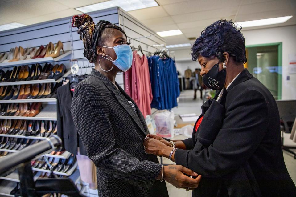 Destiny Jones, 28, of Detroit, left, tries on clothes to wear to jobs and job interviews with help from Career Image Specialist Brenda Bunnell, 66, of Detroit, left, at Jackets for Jobs boutique in Detroit on Wednesday, Dec. 8, 2021.  Jackets for Jobs also provides guidance that helps people obtain sustained employment and rebuild their lives for the long term. During the holiday season, Alison Vaughn believes the best gift thousands of Detroiters can receive is sustainable employment and she is doing her best to help deliver that gift to her fellow Detroiters through her organization Jackets For Jobs.