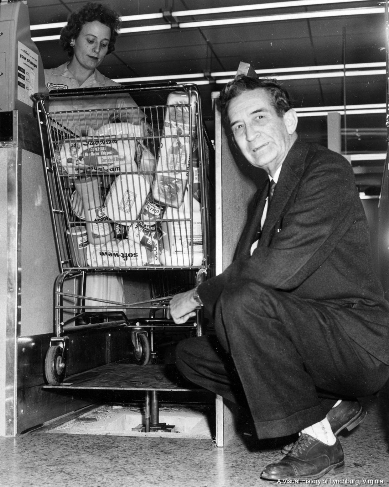 Julian J. Anderson posing in front of one of the hydraulic lifts he designed for his new store.