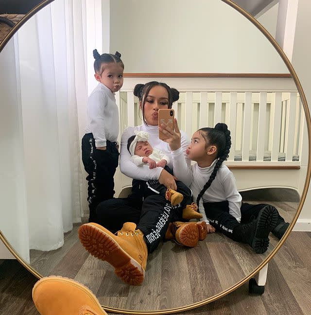 Selfie of 'kidfluencer' sisters, Mia, 5, and Tati, 3, and their mum, Nga, holding their newborn sibling