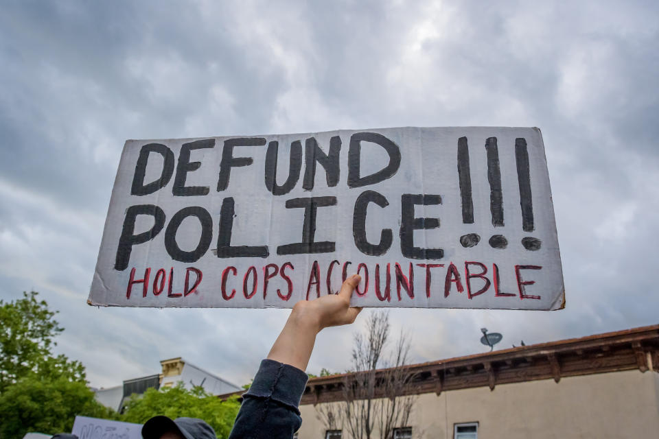 A participant holding a "Defund Police" sign at a protest. Hundreds of protesters flooded the streets of Crown Heights in Brooklyn, New York, to demand the defunding of the police force and to demonstrate against police brutality in the wake of George Floyd's death. (Photo: Erik McGregor via Getty Images)