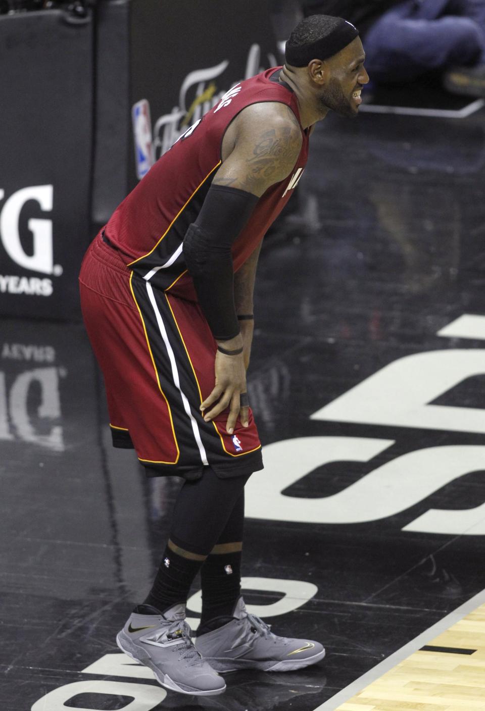 Miami Heat's LeBron James grimaces after hurting his leg during the fourth quarter against the San Antonio Spurs in Game 1 of their NBA Finals basketball series in San Antonio