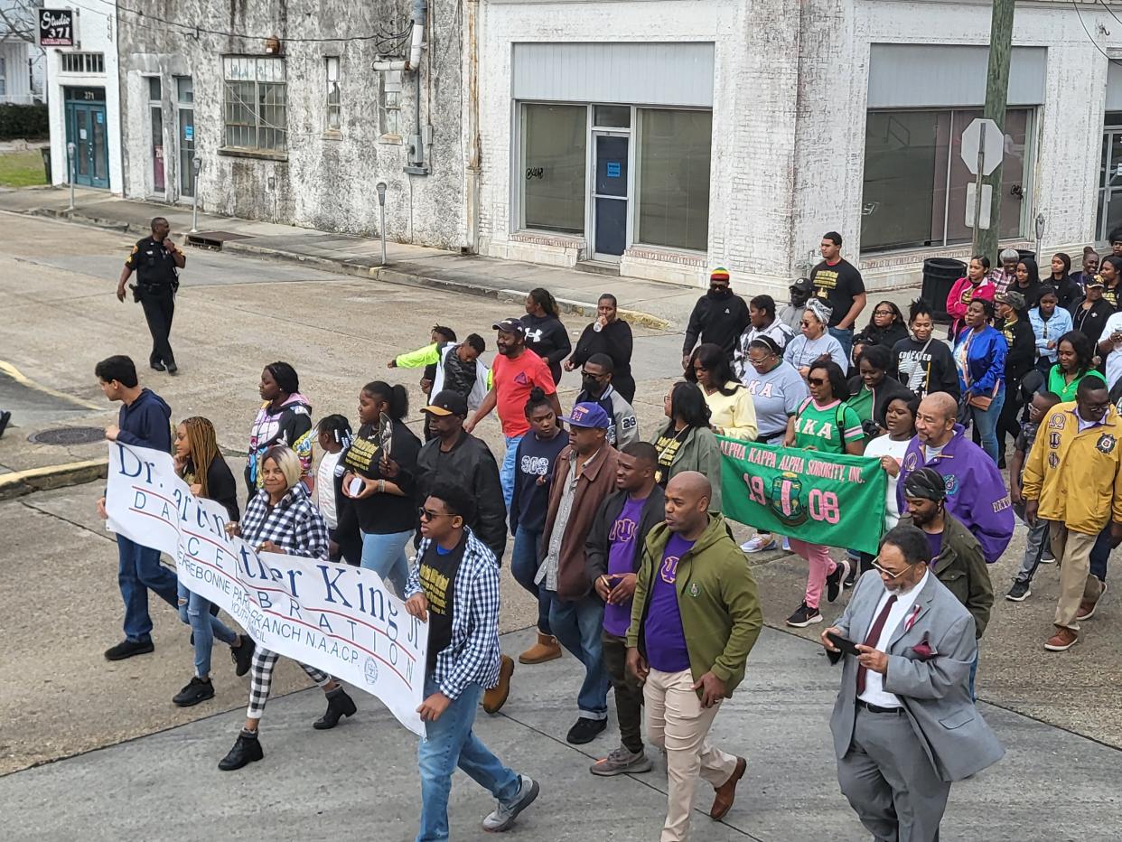Participants in Houma's Martin Luther King Day program march from the Courthouse Square to Dumas Auditorium on Monday.