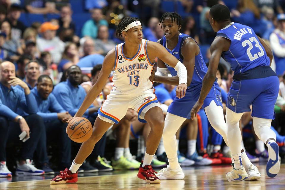 Oklahoma City Thunder's Ousmane Dieng drives toward Dallas Mavericks defenders, including McKinley Wright IV (23), during the first half of a preseason NBA basketball game in Tulsa, Okla., Wednesday, Oct. 5, 2022. (AP Photo/Dave Crenshaw)