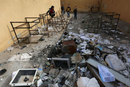 Students stand amid damaged desks and books in 'Aisha Mother of the BelieversÕ school which was recently reopened after rebels took control of al-Rai town from Islamic State militants, Syria January 17, 2017. Picture taken January 17, 2017. To match story MIDEAST-CRISIS/SYRIA-SCHOOL. REUTERS/Khalil Ashawi