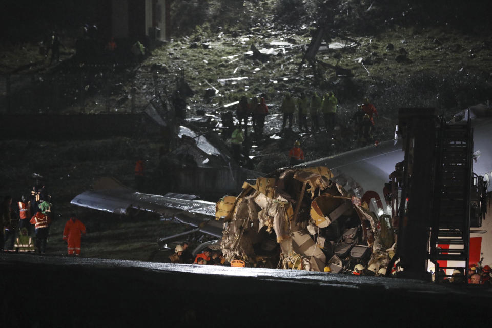 Rescue members work after a plane skidded off the runway at Istanbul's Sabiha Gokcen Airport, Wednesday, Feb. 5, 2020. A plane skidded off the runway Wednesday at Istanbul’s Sabiha Gokcen Airport, crashing into a field and breaking into pieces. Passengers were seen evacuating through cracks in the plane and authorities said at least 21 people were injured. (AP Photo)