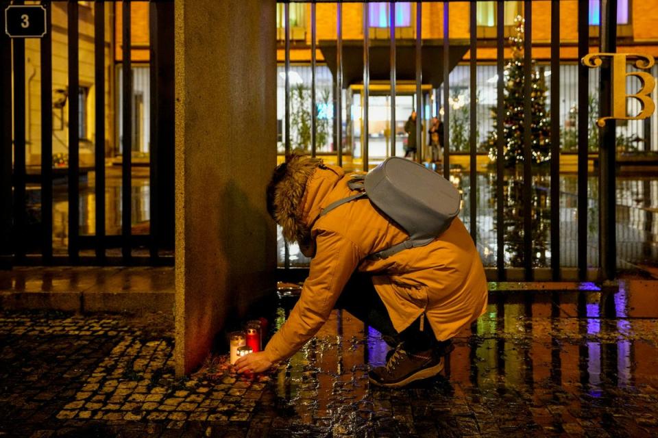 A woman lights candles outside the building of Philosophical Faculty of Charles University in downtown Prague (AP Photo/Petr David Josek). (AP)