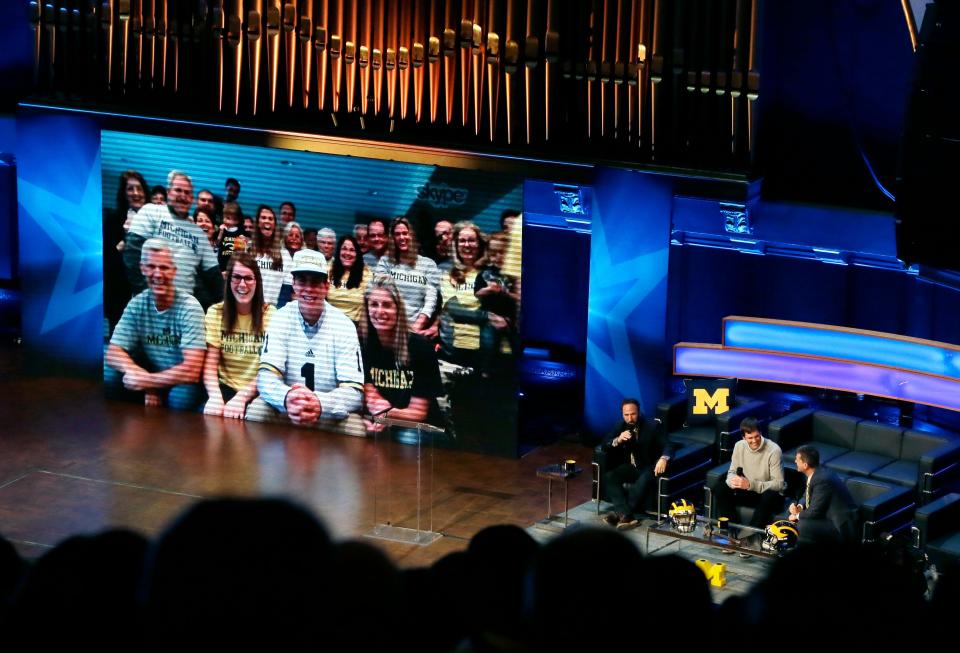 Michigan football coach Jim Harbaugh, bottom right, and former quarterback Tom Brady, bottom center, introduce kicker Quinn Nordin on the screen for fans at the Signing With the Stars spectacle Feb. 3, 2016 in Ann Arbor.