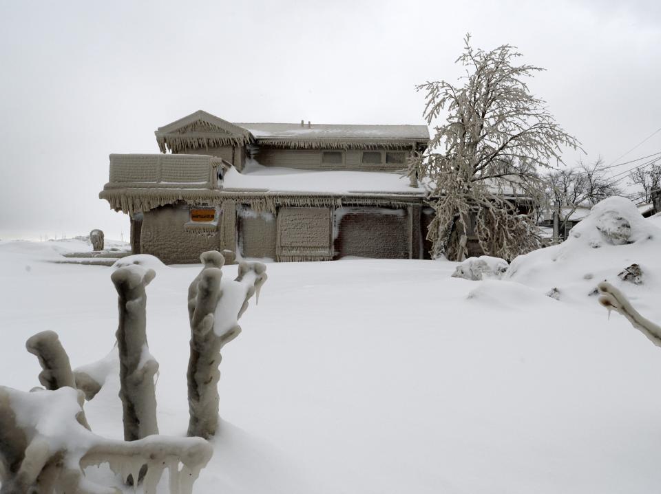 Homes are covered with ice after being battered with waves from Lake Erie along Hoover Beach on December 27, 2022 in Hamburg, New York.