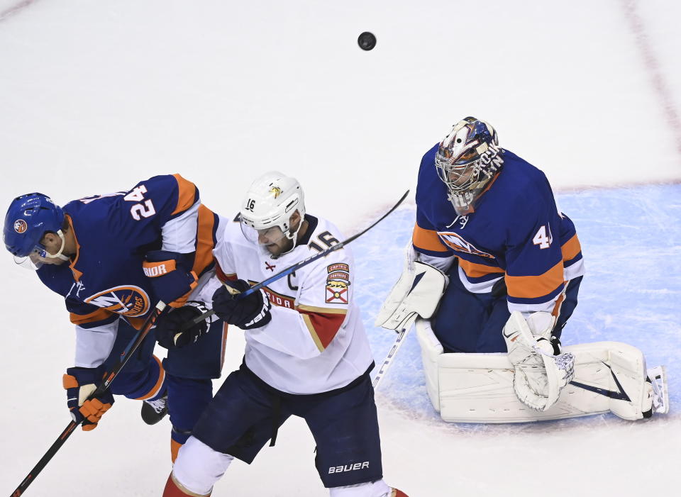 New York Islanders goaltender Semyon Varlamov (40) makes a save as Florida Panthers center Aleksander Barkov (16) and Islanders defenseman Scott Mayfield (24) battles for position during the first period of an NHL Stanley Cup playoff hockey game in Toronto, Tuesday, Aug. 4, 2020. (Nathan Denette/The Canadian Press via AP)