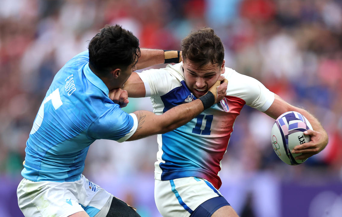 PARIS, FRANCE - JULY 24: Antoine Dupont #11 of Team France is challenged by Bautista Basso #5 of Team Uruguay during the Men's Rugby Sevens Pool C Group match between France and Uruguay on Day -2 of the Olympic Games Paris 2024 at Stade de France on July 24, 2024 in Paris, France. (Photo by Cameron Spencer/Getty Images)